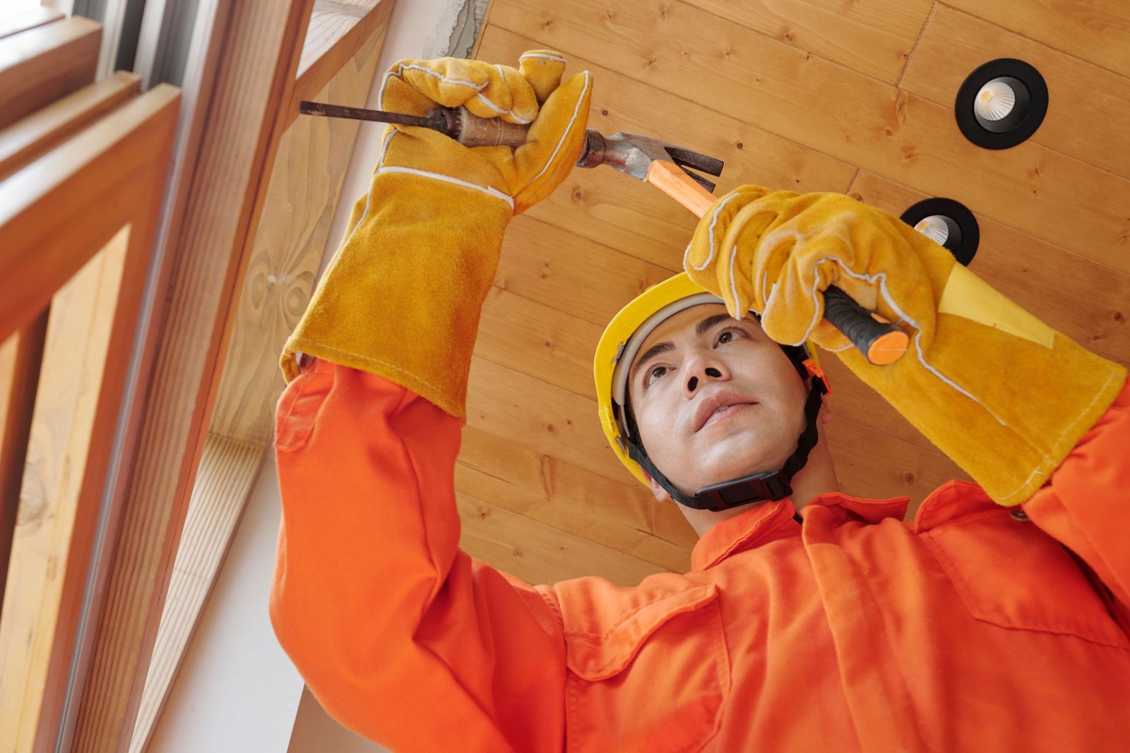 Technician in protective gear repairing a household fixture indoors